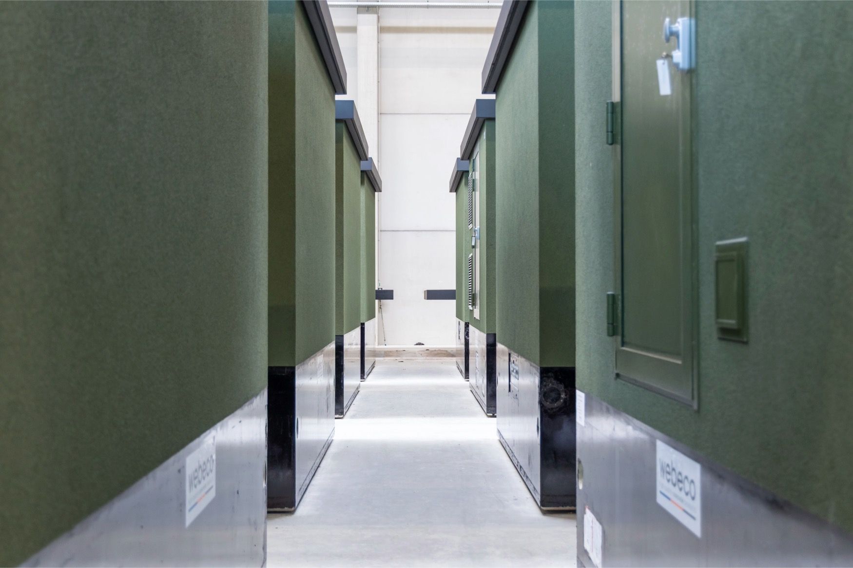 Prefab elektriciteitscabines van Webeco in lijnopstelling, met focus op afwerking en kwaliteit in productie.